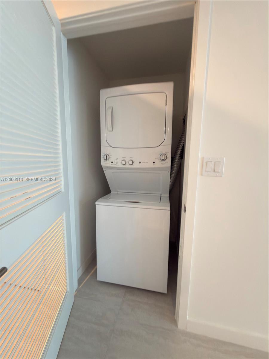 A stacked washer and dryer unit is located inside a small utility closet — 77 SE 5th St # 1602, Miami FL 33131, MIAMI, FL