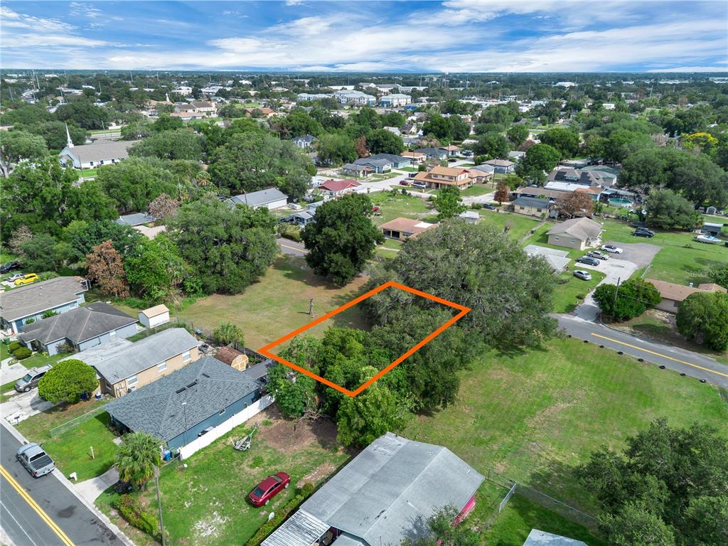 An aerial view shows a rectangular vacant lot outlined in orange amidst a residential neighborhood — PALMETTO AVENUE NE, WINTER HAVEN, FL