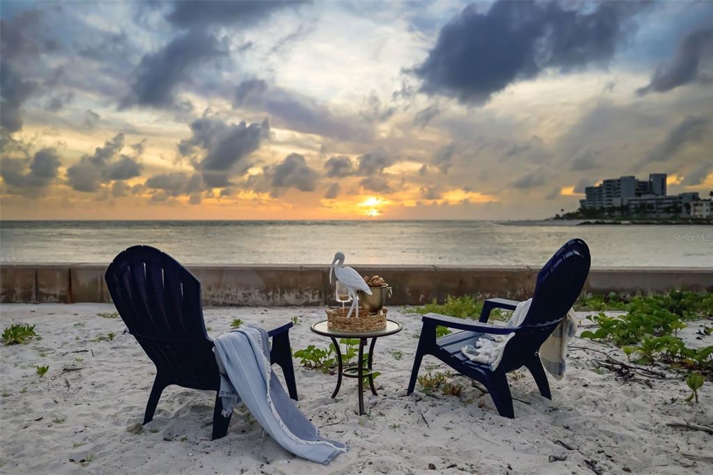 Two dark blue Adirondack chairs face the ocean on a sandy beach at sunset — 1157 WESTWAY DRIVE, SARASOTA, FL