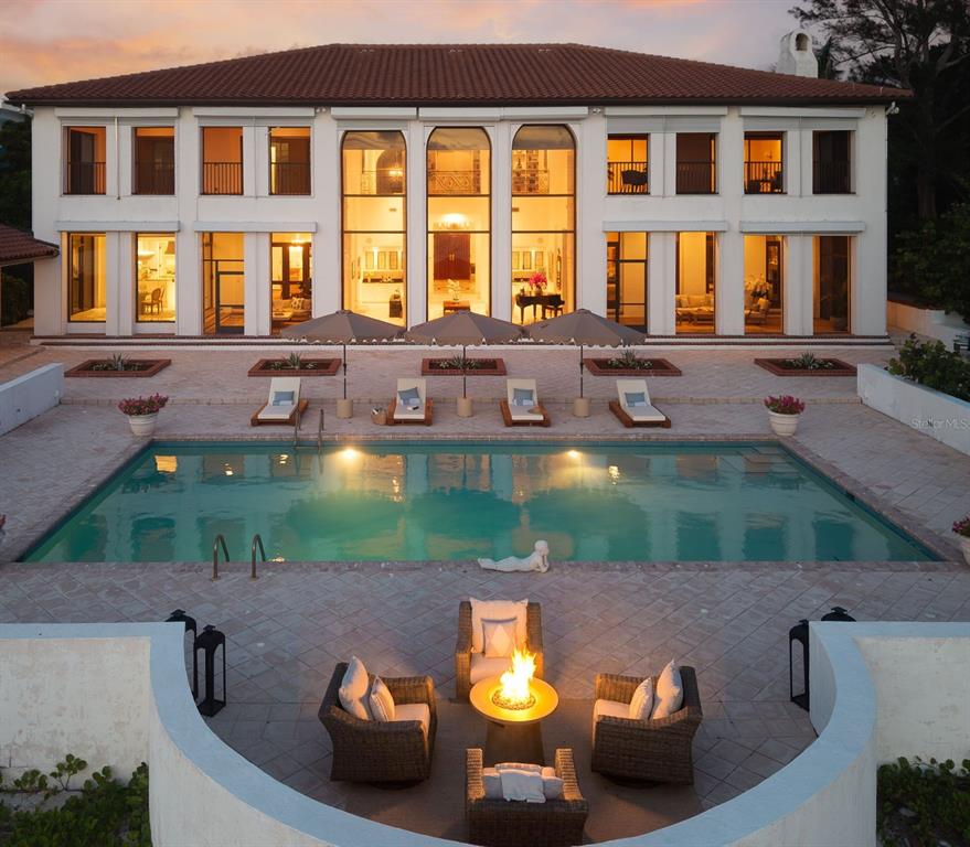 An aerial view of a two-story mansion with a pool, patio, and fire pit area — 1157 WESTWAY DRIVE, SARASOTA, FL