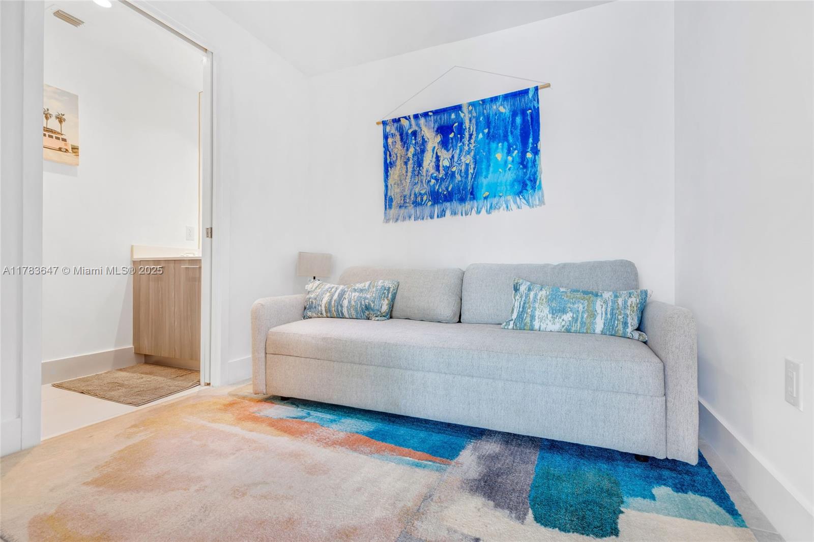 A room features a light gray sofa, a colorful area rug, and wall-mounted artwork — 501 NE 31 St # 3307, Miami FL 33137, MIAMI, FL