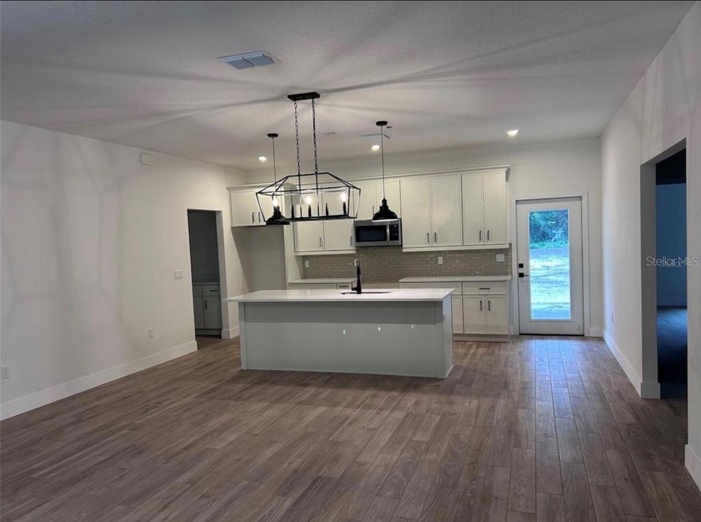 A kitchen with white cabinetry, a central island, and wood-look tile flooring — 330 KIMBLE AVENUE, OVIEDO, FL