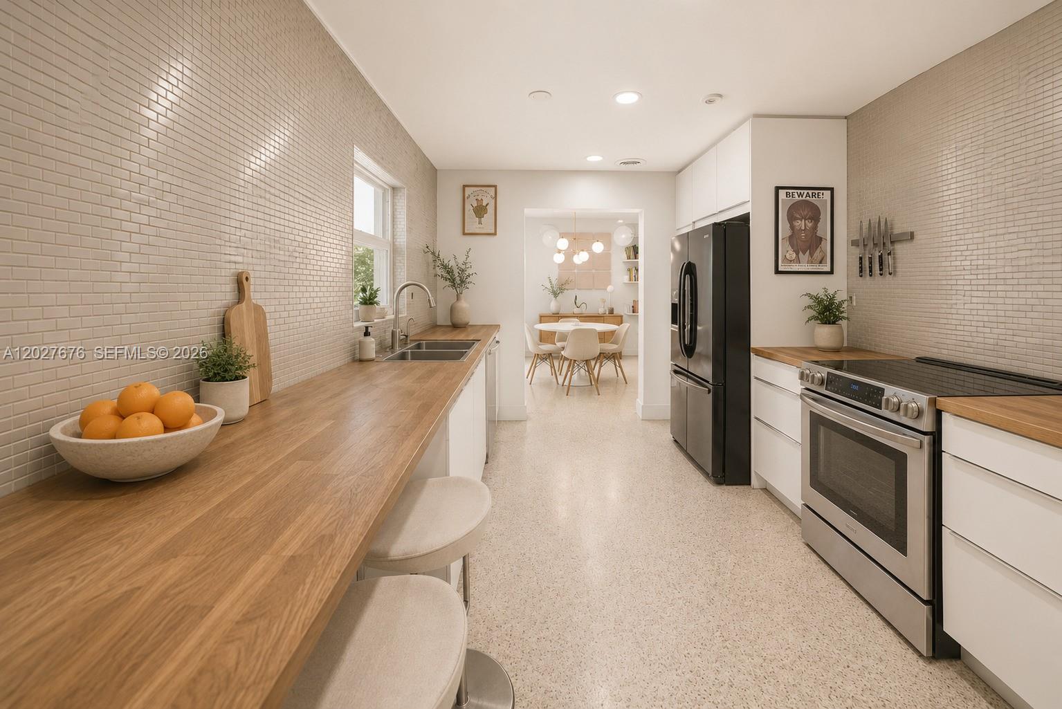 A galley kitchen features white cabinets, wood countertops, a stainless steel stove, and tiled walls — 14001 S Biscayne River Dr, Miami FL 33161, MIAMI, FL