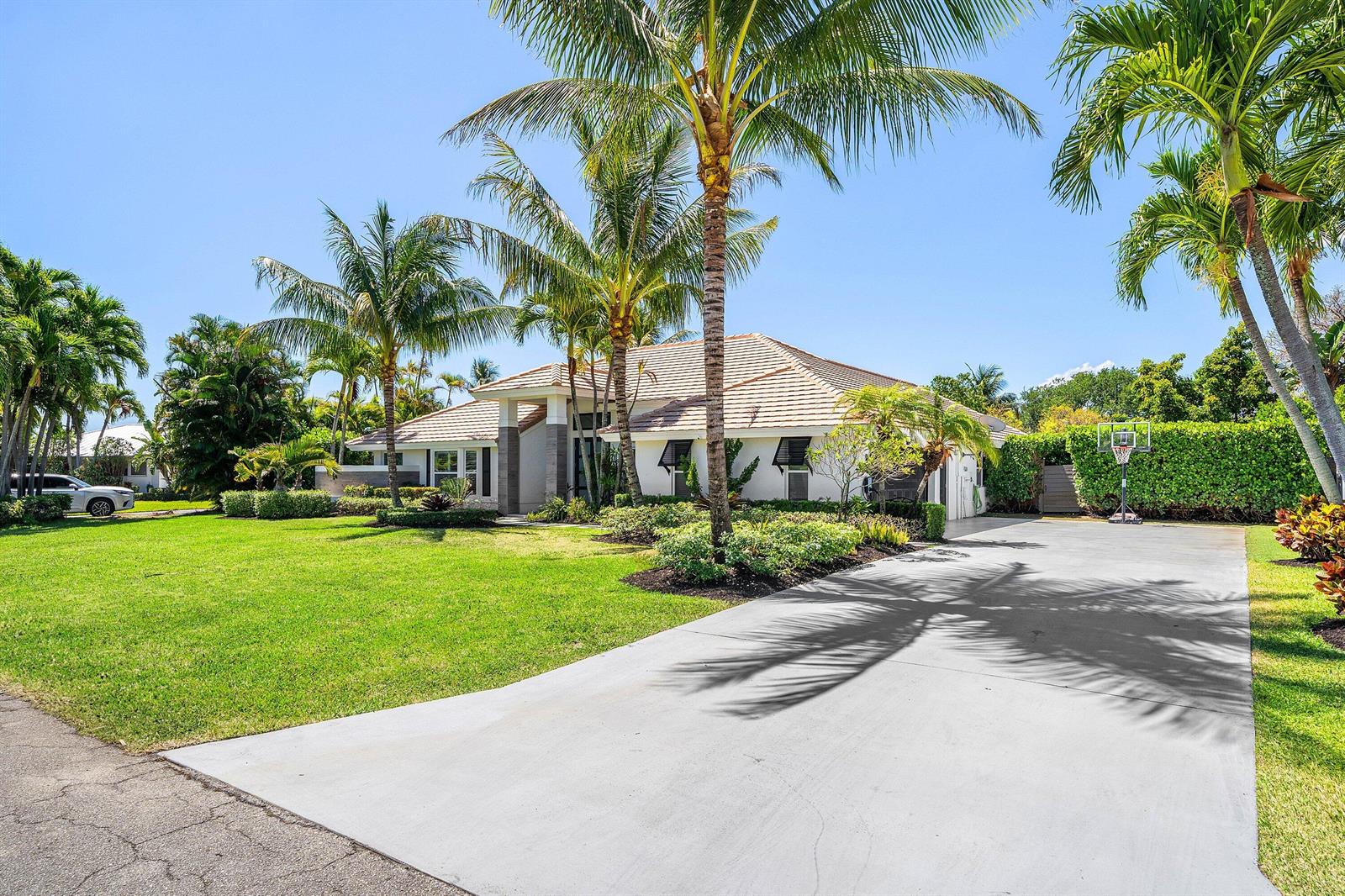 A single-story house with a concrete driveway, palm trees, and a green lawn — 916 SW 37th Court, Boynton Beach FL 33435, BOYNTON BEACH, FL