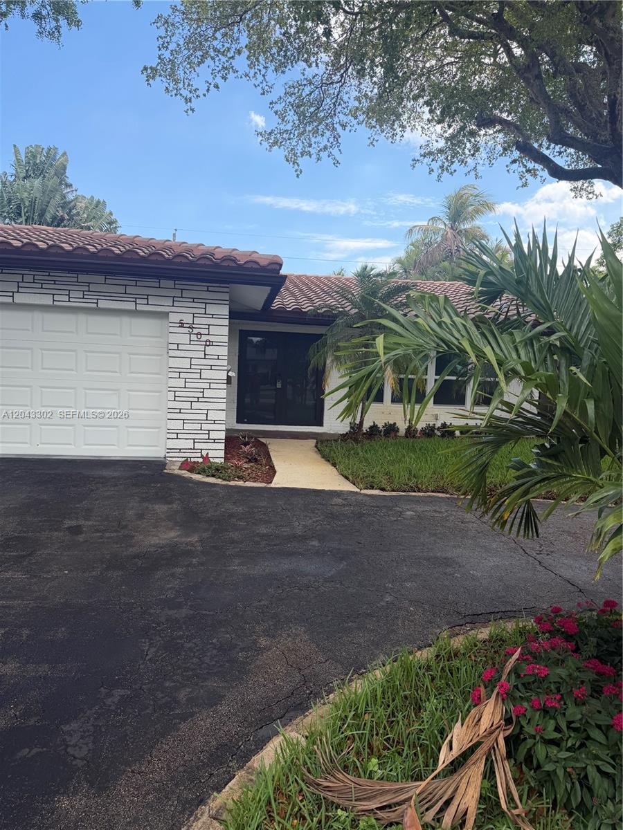 A single-story house features a white brick facade, a tiled roof, and a paved driveway — 5300 Adams St, Hollywood FL 33021, HOLLYWOOD, FL