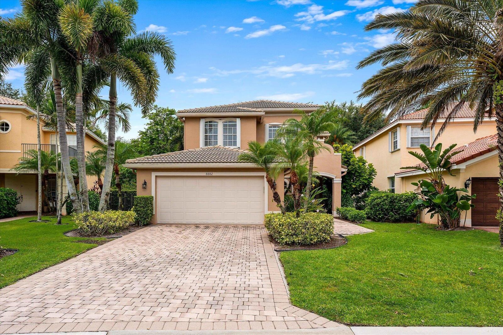 A two-story suburban house with a beige stucco exterior, tile roof, and paved driveway — 8882 Hidden Acres Drive, Boynton Beach FL 33473, BOYNTON BEACH, FL