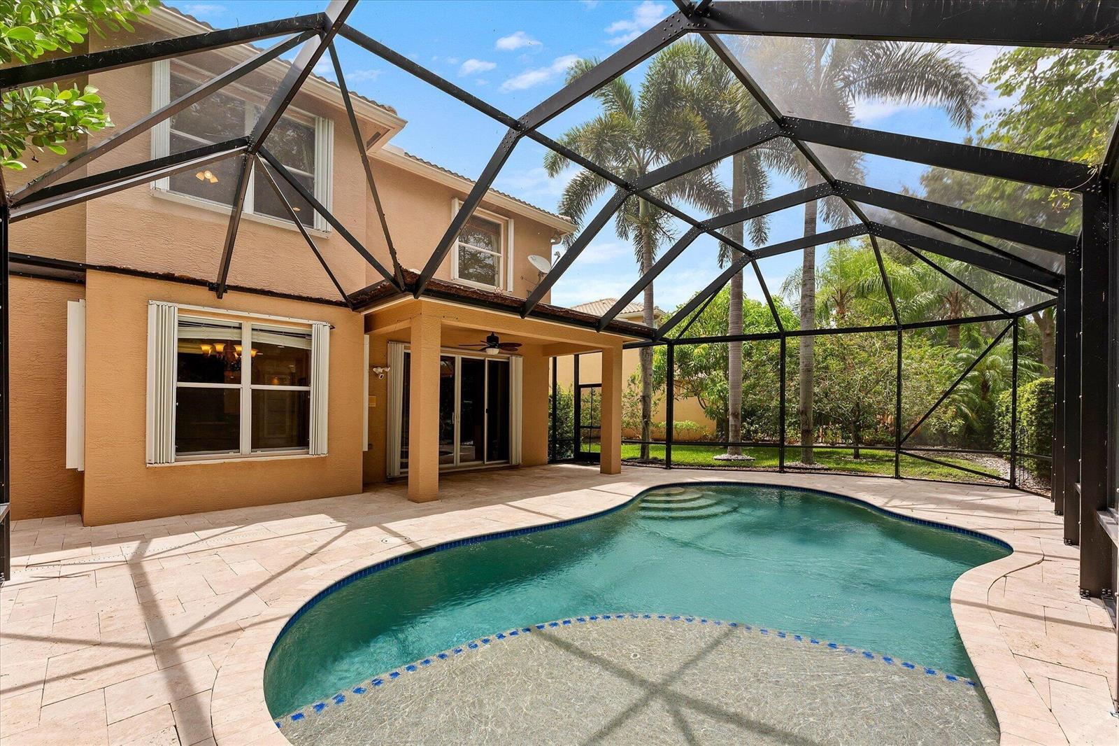 A backyard swimming pool with a screened-in enclosure and a tan two-story house exterior — 8882 Hidden Acres Drive, Boynton Beach FL 33473, BOYNTON BEACH, FL