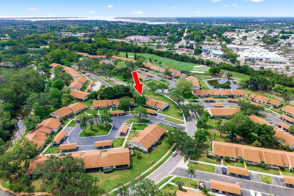 An aerial view shows a residential complex with multiple buildings featuring orange roofs and parking — 20 EVELYN COURT, OLDSMAR, FL