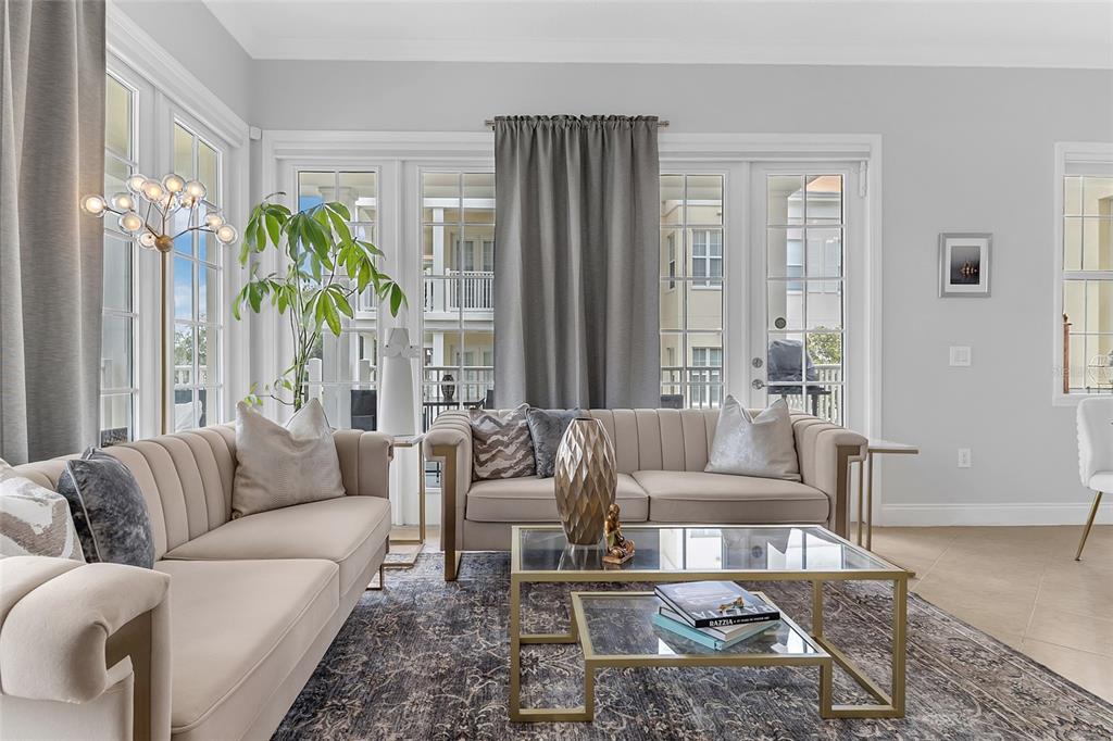 A living room features two beige sofas, a glass coffee table, and a large rug — 7474 EXCITEMENT DR UNIT 203, REUNION, FL