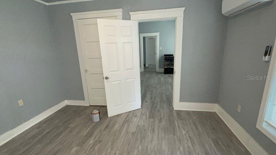 A room with light gray walls, wood-look flooring, and two open doorways leading to other rooms — 706 HARVEY, DAYTONA BEACH, FL