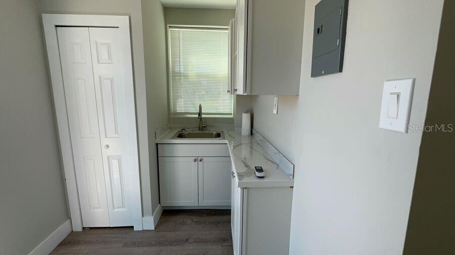 A small kitchen area features white cabinets, a stainless steel sink, and light-colored countertops — 706 HARVEY, DAYTONA BEACH, FL