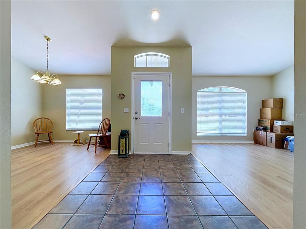 An entryway with tiled flooring leads to a front door flanked by two living areas — 12803 YARN PLACE, RIVERVIEW, FL