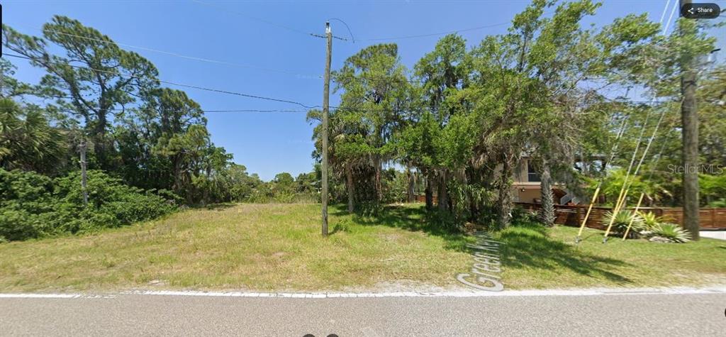 A vacant, grassy lot with trees and utility poles sits along a paved road — 4599 GREEN KEY ROAD, NEW PORT RICHEY, FL