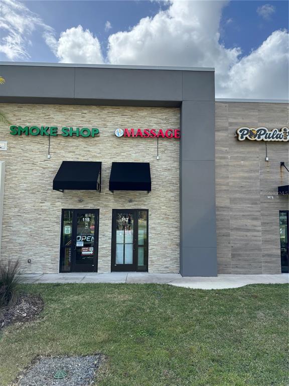An exterior view of a commercial building featuring a smoke shop and a massage business — 3370 ROUSE ROAD UNIT 117, ORLANDO, FL
