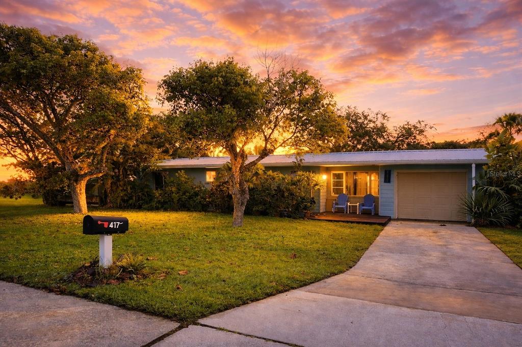 A single-story house with a light blue exterior, a garage, and a sunset sky — 617 GOODWIN AVENUE, NEW SMYRNA BEACH, FL