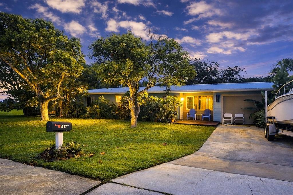 A single-story house with a lawn, driveway, and a boat parked on a trailer — 617 GOODWIN AVENUE, NEW SMYRNA BEACH, FL