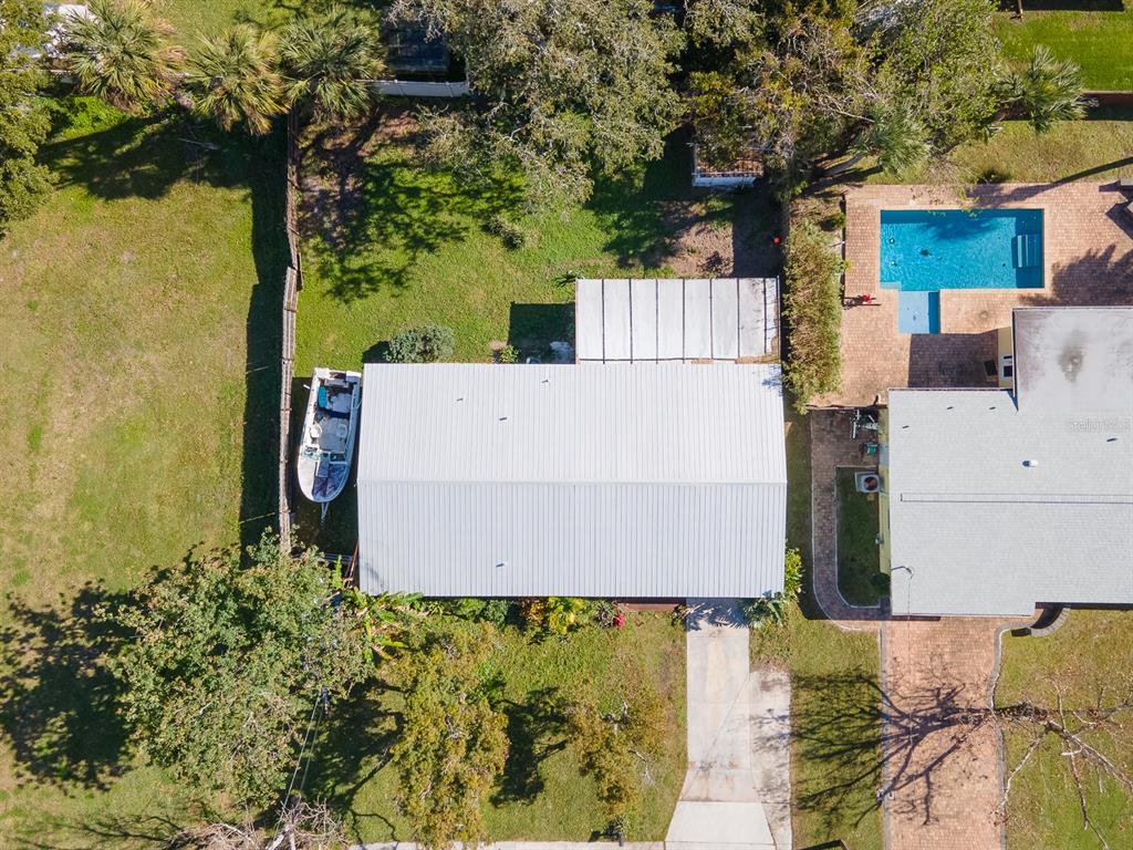 An aerial view shows a house with a metal roof, a boat, and a pool — 617 GOODWIN AVENUE, NEW SMYRNA BEACH, FL