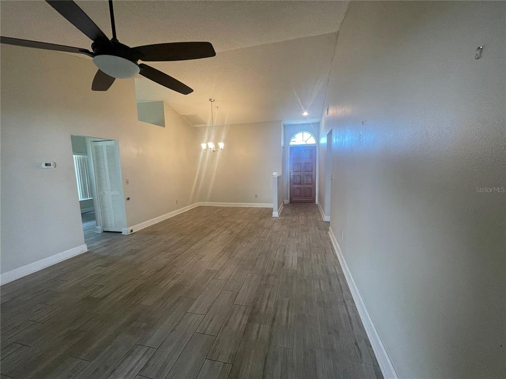 An open living area features vaulted ceilings, a ceiling fan, and light-colored wood-look tile flooring — 13104 BARTH PLACE UNIT 13104, RIVERVIEW, FL