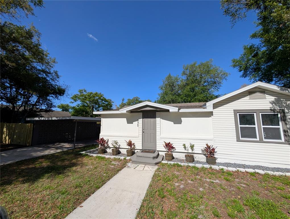 A single-story house with white siding, a gray front door, and a covered carport — 739 CENTER STREET, WAVERLY, FL