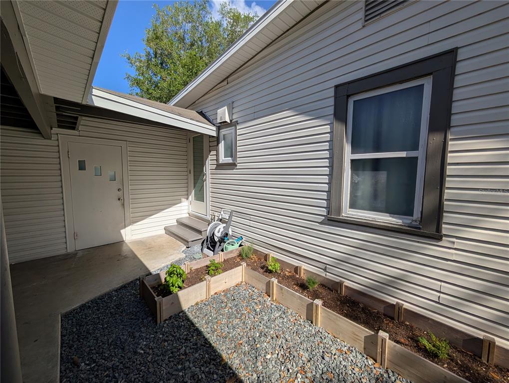 An exterior view shows a house with light siding, a small garden bed, and gravel — 739 CENTER STREET, WAVERLY, FL