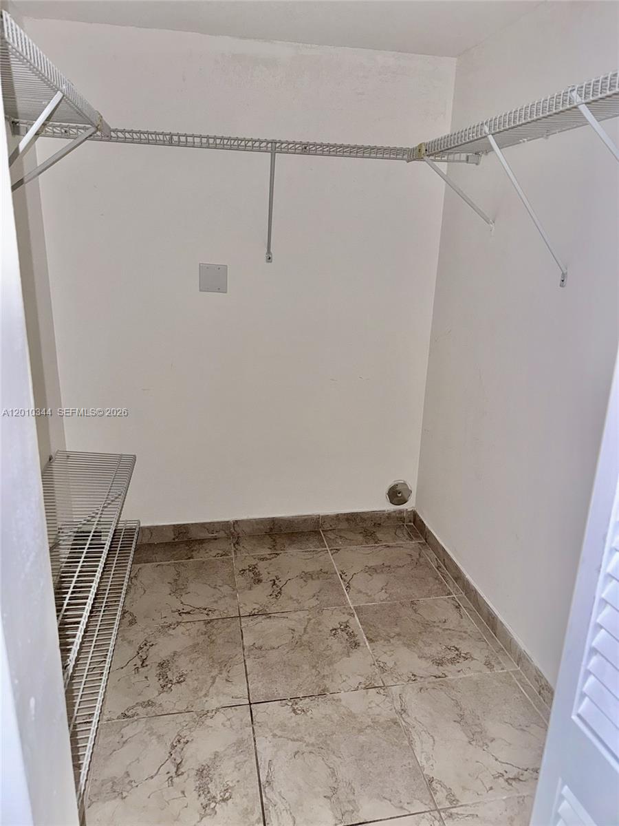 A walk-in closet features wire shelving, white walls, and light-colored tile flooring — 8933 SW 123rd Ct # 108, Miami FL 33186, MIAMI, FL