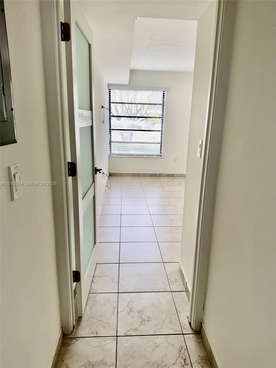 A doorway leads into a small, tiled room featuring a window with horizontal blinds — 8933 SW 123rd Ct # 108, Miami FL 33186, MIAMI, FL