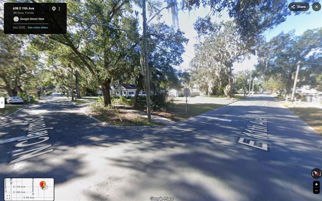 A street-level view of a residential intersection with large trees and a stop sign — CLAYTON STREET N, MOUNT DORA, FL