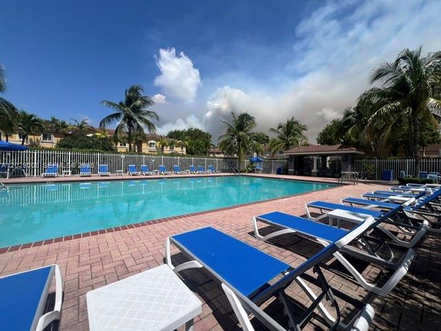 A swimming pool with lounge chairs on a brick deck surrounded by palm trees — 8258 NW 108th Pl # 4, Doral FL 33178, DORAL, FL