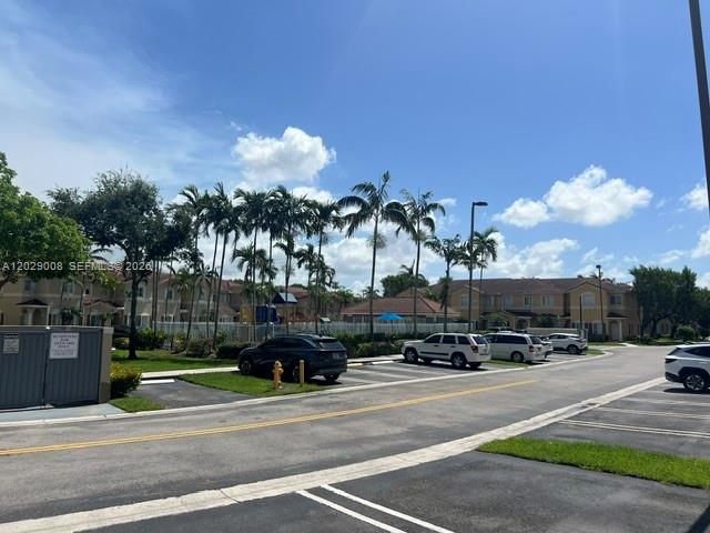 A parking lot sits in front of multi-story residential buildings surrounded by palm trees — 8258 NW 108th Pl # 4, Doral FL 33178, DORAL, FL
