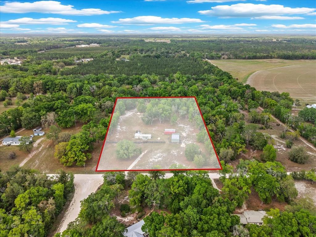 An aerial view shows a rectangular property lot with a house and shed among trees — 3100 NW 20TH STREET, BELL, FL