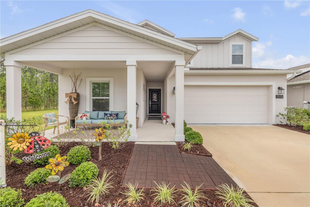 A single-story house with a covered front porch, a two-car garage, and landscaped yard — 1105 PACIFIC DUNES COURT, DAYTONA BEACH, FL