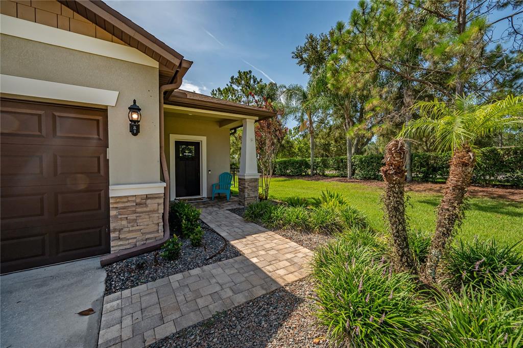 A paved walkway leads to the front entrance of a house with a garage — 4342 O ROURKE COURT, WESLEY CHAPEL, FL