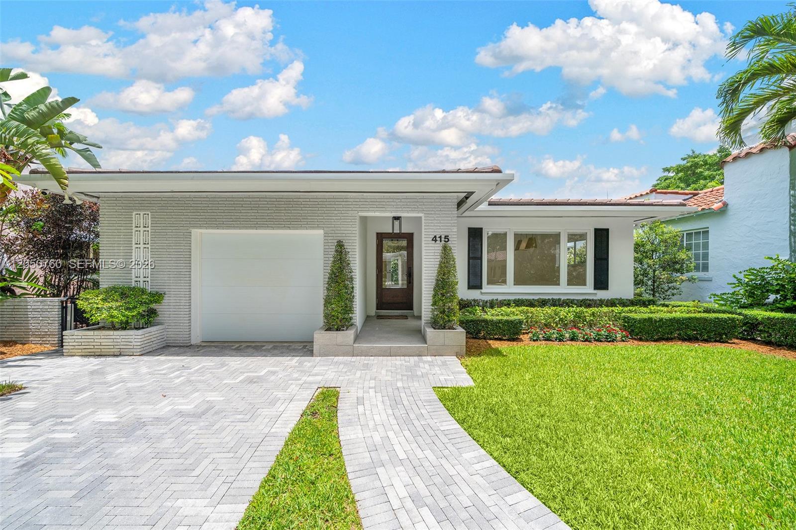 A single-story house with a white brick facade, a garage, and a paved driveway — 415 Navarre Ave, Coral Gables FL 33134, CORAL GABLES, FL