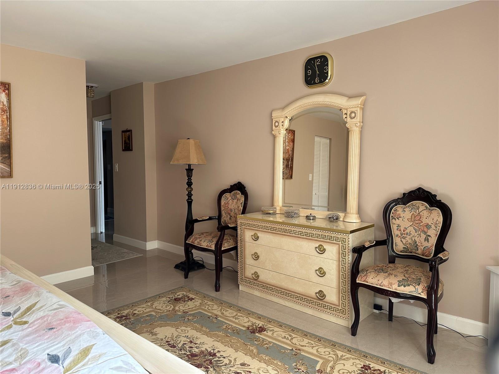 A bedroom features a dresser with a mirror, two patterned chairs, and a floor lamp — 1865 S Ocean Dr # 6H, Hallandale Beach FL 33009, HALLANDALE BEACH, FL