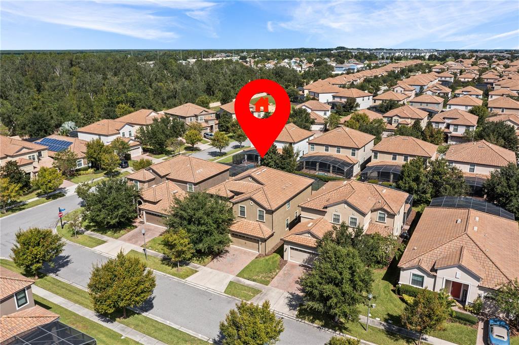 An aerial view shows a two-story suburban house with a tiled roof and backyard pool — 9117 EL CARO LANE, DAVENPORT, FL