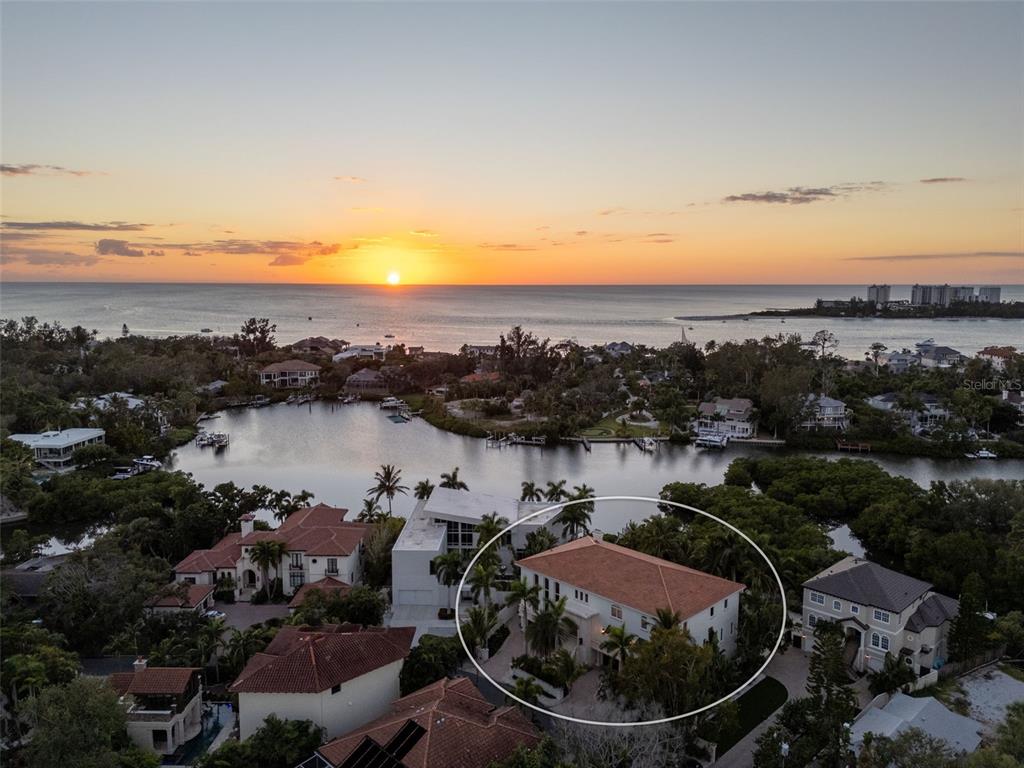 An aerial view shows a two-story house with a red tile roof near the water — 4136 ROBERTS POINT CIRCLE, SARASOTA, FL