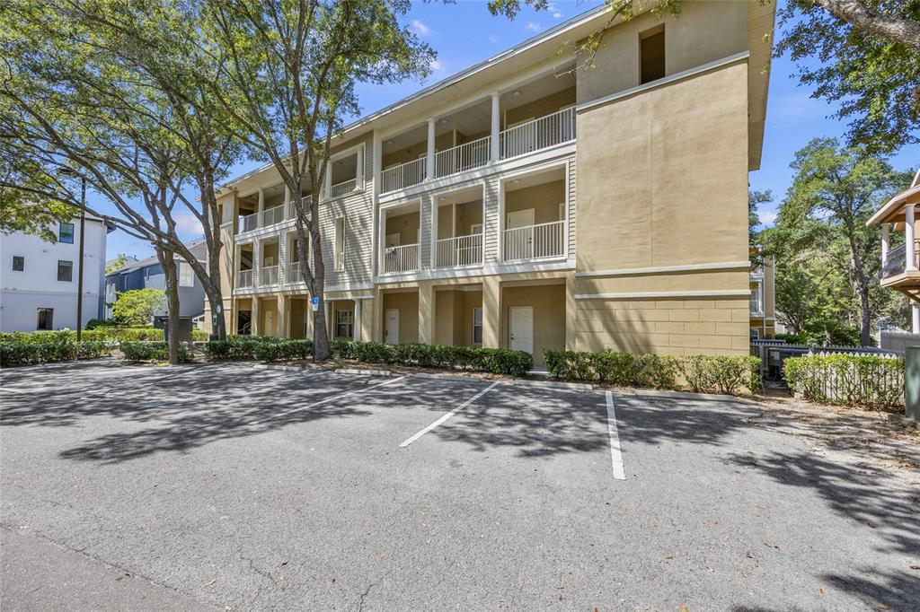 A three-story apartment building with balconies and a paved parking lot in front — 4941 SW 91ST TERRACE UNIT N301, GAINESVILLE, FL