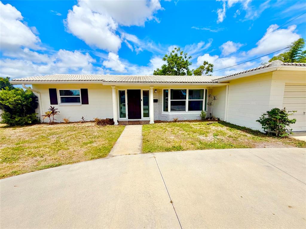 A single-story house with a light-colored exterior, a concrete driveway, and a front walkway — 3300 58TH STREET N, ST PETERSBURG, FL
