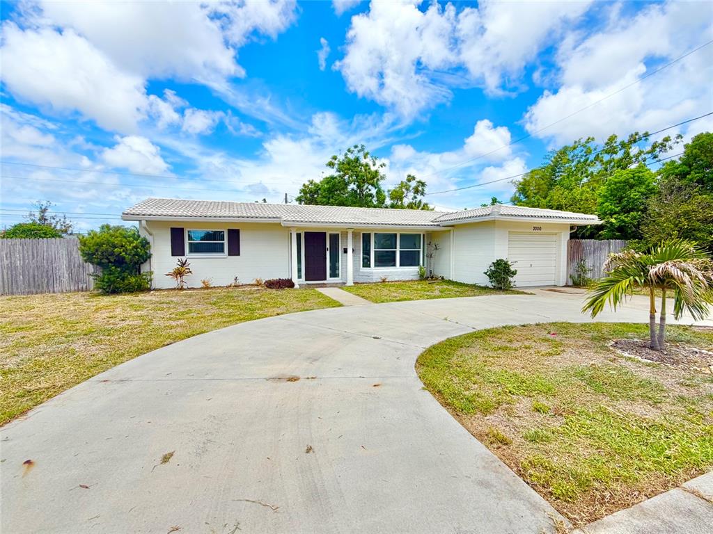 A single-story house with a white exterior, a tiled roof, and a curved concrete driveway — 3300 58TH STREET N, ST PETERSBURG, FL