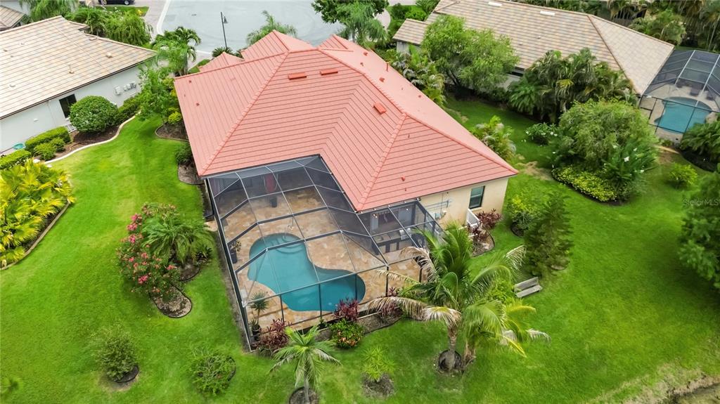 An aerial view of a house with a red tile roof and a screened-in pool — 8057 RIO BELLA PLACE, UNIVERSITY PARK, FL
