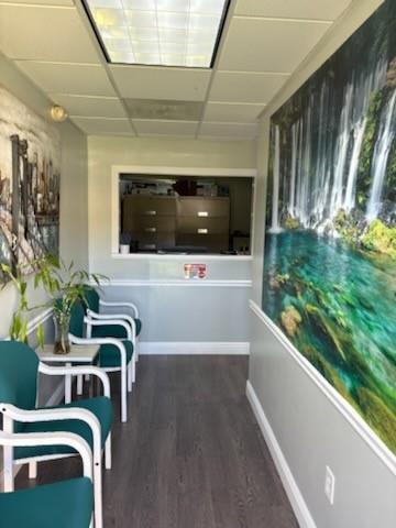A waiting room features teal chairs, wood-look flooring, and a large waterfall wall mural — PEMBROKE PINES, FL
