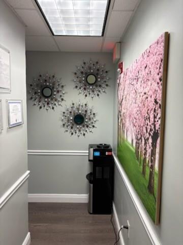 A hallway features a water cooler, three sunburst mirrors, and a large cherry blossom wall art — PEMBROKE PINES, FL