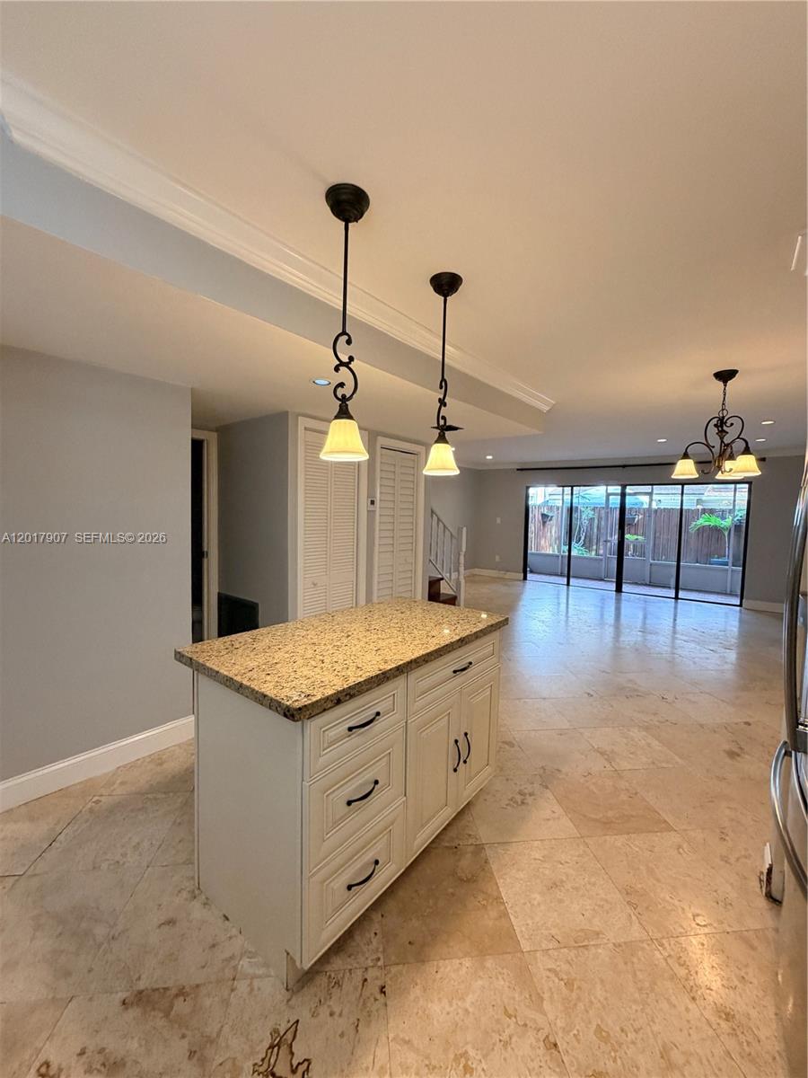 A kitchen island with a granite countertop sits in a room with tile flooring — 3300 Atlanta # 15C, Hollywood FL 33021, HOLLYWOOD, FL