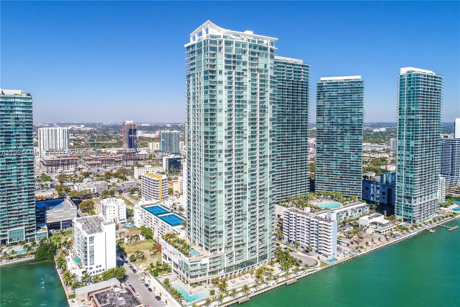 An aerial view of several tall glass skyscrapers situated along a waterfront in a city — 2900 NE 7th Ave # 404, Miami FL 33137, MIAMI, FL