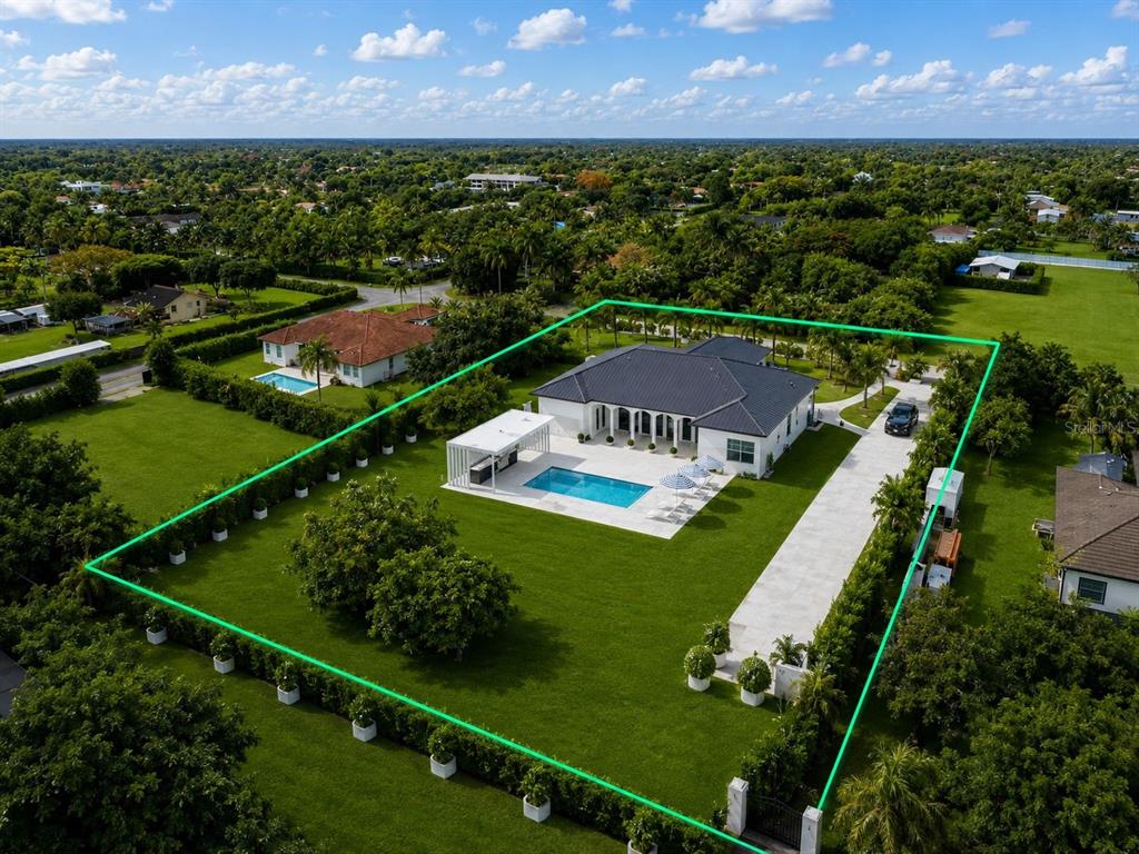 An aerial view of a single-story house with a pool, patio, and large fenced yard — 23710 SW 214TH PLACE, HOMESTEAD, FL