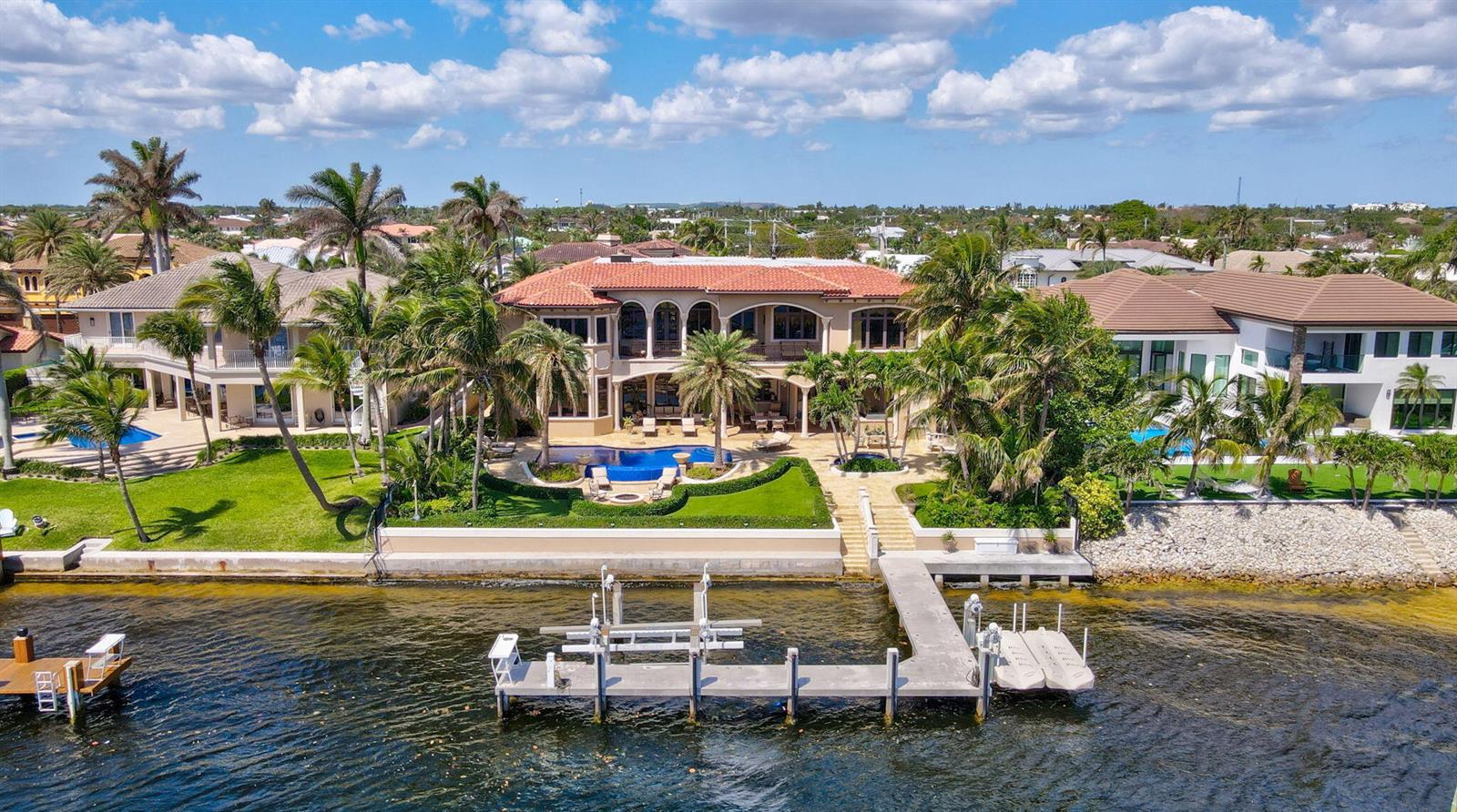 An aerial view of a waterfront mansion with a pool, dock, and palm trees — 3870 NE 31st Avenue, Lighthouse Point FL 33064, LIGHTHOUSE POINT, FL