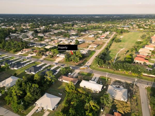 An aerial view shows a residential lot marked as property near a road and houses — 4912 LEONARD BLVD S, Lehigh Acres FL 33973, LEHIGH ACRES, FL
