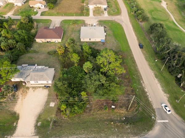 An aerial view shows a vacant, tree-covered lot situated between two residential houses — 4912 LEONARD BLVD S, Lehigh Acres FL 33973, LEHIGH ACRES, FL