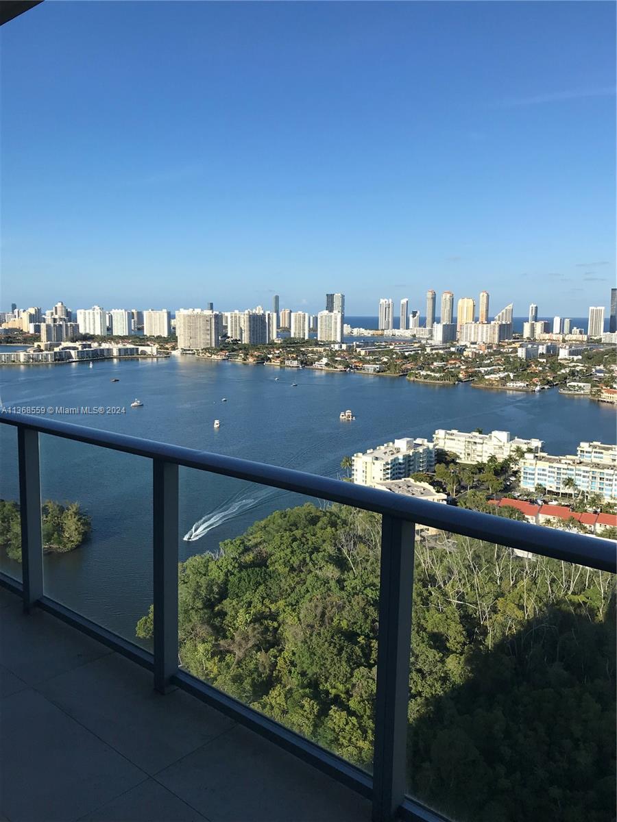 A high-rise balcony overlooks a bay with a city skyline in the distance — 16385 Biscayne Blvd # 7, North Miami Beach FL 33160, NORTH MIAMI BEACH, FL