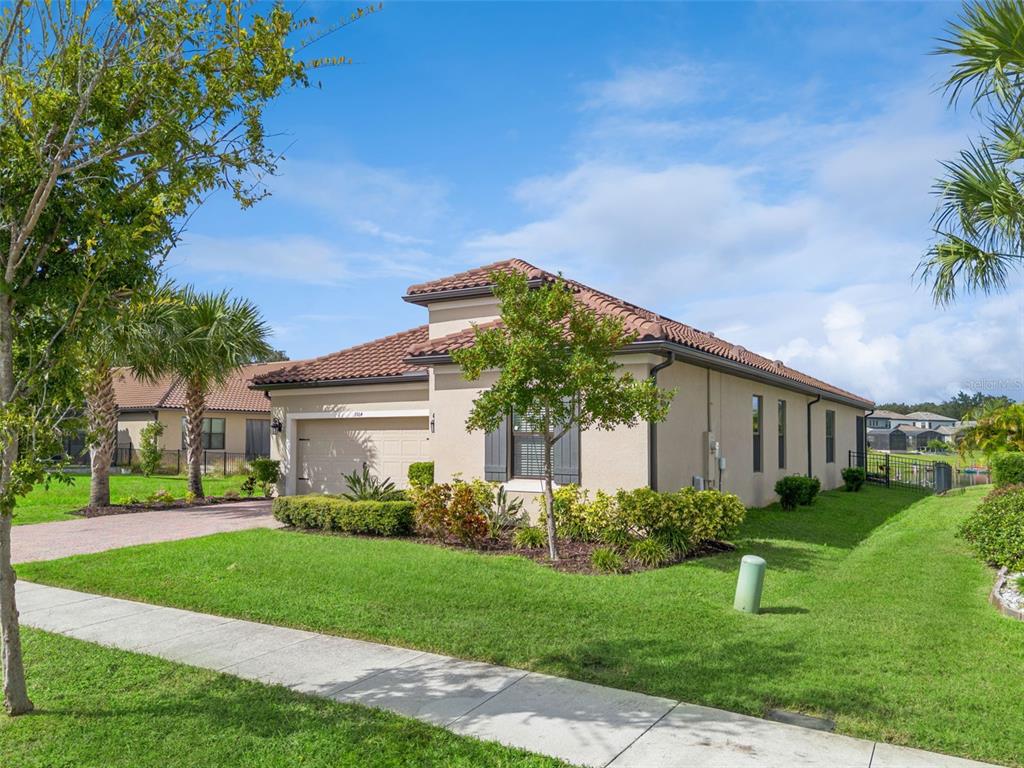 A beige single-story house with a tiled roof and a paved driveway sits on grass — 3964 CARRICK BEND DR, KISSIMMEE, FL